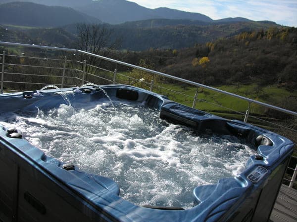 Spa extérieur du Domaine du Gomm avec vue panoramique sur les crêtes vosgiennes, disponible en option