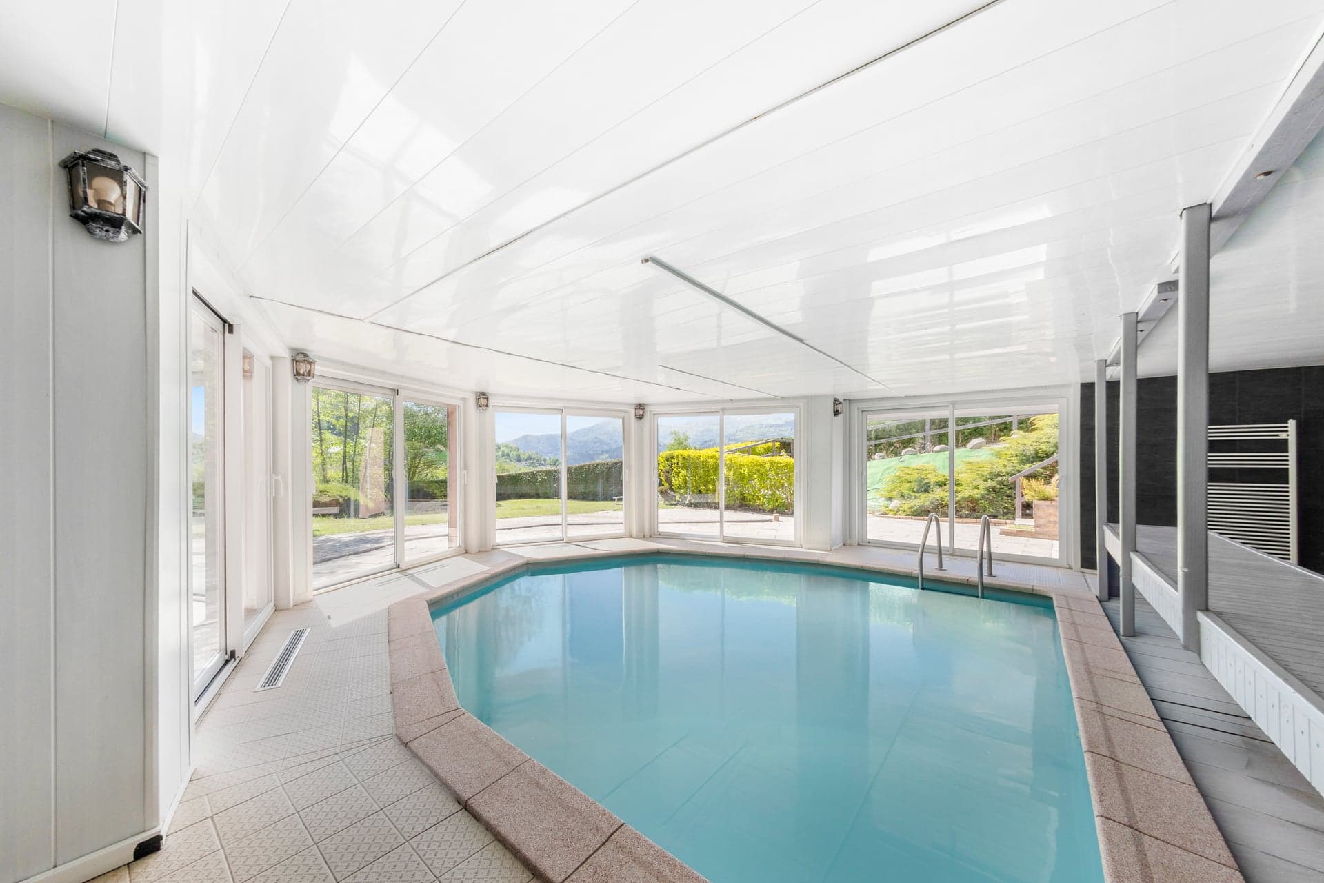 Piscine couverte du gîte Gentiane avec verrière panoramique et vue sur les Hautes-Vosges (gîte avec piscine 15 personnes Alsace)